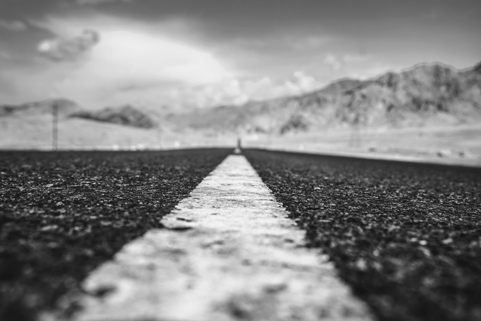 A long, open road with a central white line stretching into the horizon, symbolising direction and progress.